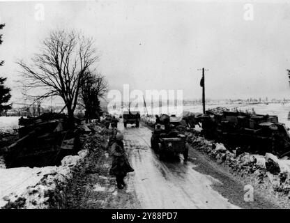 Fortschreitende US-Truppen Schau über die ausgebrochenen Nazi-Panzer -- fortschreitende US-Soldaten passieren zerstörte deutsche Panzer und Fahrzeuge, die die Straße nach Bullange, Belgien säumen. Von den 700 Feinddanken, die in die unglückliche Ardennenoffensive geworfen wurden, wurden 500 außer Gefecht gesetzt. Bis zum 1. Februar 1945 hatten die Alliierten den gesamten Boden zurückgewonnen, der ursprünglich im Salient verloren war. März 1945. (Foto von zugehörigem Pressefoto). Stockfoto