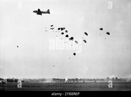 King and Queen at R.A.F. Display: A Handley Page 'H as Tings' lässt die Arme durch Fallschirme an die 'entflohenen Gefangenen' nach den Amiens fallen. Die Gefängnismauer wurde von Mücken in der RAF-Anzeige durchbrochen. Der König und die Königin beobachteten heute die Royal Air Force auf Herz und Nieren bei der RAF-Ausstellung. Farnborough wurde nach 13 Jahren wiederbelebt. Einer der Höhepunkte der Show war die Nachstellung des gewagten Überfalls auf das Amiens Gefängnis, als tief fliegende Misquitoes den gefangenen Franzosen befreiten, indem sie die Mauern des Gefängnisses durchbrachen. Mehr als ***** 220 Flugzeuge nehmen ebenfalls an einer Massentlüftung Teil. Juli 1950. (Foto: Fox P. Stockfoto