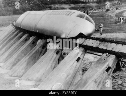 Auf dem Weg in das zukünftige „Monorail“-Debüt von Maess – eine Geschwindigkeit von 14c Kilometern pro Stunde der „Monorail“-Zug fährt durch eine kurvige Strecke auf der Teststrecke, die Kurve der Strecke ist fast geneigt, um hohe Geschwindigkeiten zu ermöglichen. Der Zug der Zukunft, der 180 bis 210 Stundenkilometer auf einem Gleis erreichen soll, war stolz auf ***** Hier vom Sponsor, Schwedisch. Der Multimillionär Axel L. Wenner-Gren und die beiden deutschen Erfinder Joseph Hinsken und Georg Holzer, beide aus Köln. Die ersten Vorführungen der Einschienenbahn fanden in Fuelingen bei Köln in einem starken ***** statt Von Zaun umzingelte Heide A Stockfoto