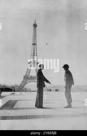 Hitler war hier... vor vier Jahren -- Ein Franzose (links) im befreiten Paris zeigt auf die Stelle vor dem Eiffelturm (Hintergrund), als er einem amerikanischen Soldaten (rechts) erzählt, wo Adolf Hitler am 14. Juni 1940 stand, nachdem die Deutschen die französische Hauptstadt besetzt hatten. Das berühmte Wahrzeichen fliegt wieder die französische Tricolor. August 1944. (Foto von Associated Press Radiophoto). Stockfoto