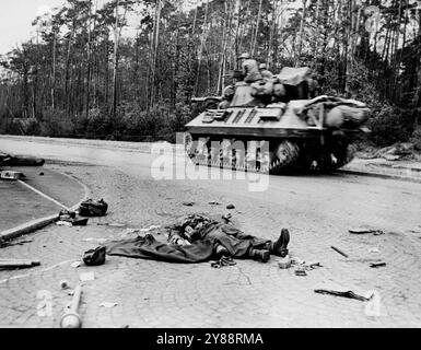 US-Panzer rastet in Richtung Frankfurt -- Ein Panzer der sechsten gepanzerten dritten US-Armee, fährt an zwei toten Nazi-Bazooka-Kanonen vorbei, die von zerrissener Ausrüstung umgeben liegen. Er fährt in Richtung Frankfurt, Deutschland, 27. märz 1945. 3. Armeeeinheiten räumten die Stadt, 27 Meilen Küste des Rheins, am 29. März. März 1945. (Foto von U.S. Office of war Information Picture). Stockfoto