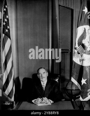 Acheson am Schreibtisch des Sekretärs -- Dean Acheson, neuer Außenminister, posiert heute an seinem Schreibtisch im Gebäude des Außenministeriums. Er sitzt zwischen der Flagge der Vereinigten Staaten (links) und der Flagge des Außenministers. Acheson wurde gestern als Nachfolger von General George C. Marshall vereidigt. Januar 1949. (Foto von AP Wirephoto). Stockfoto