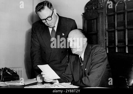 Australien Recruiting Rook Workers in Großbritannien -- Mr. Beals, Australiens Min. Of Supply – derzeit in Großbritannien – einige der Anträge mit Herrn R. E. Armstrong, Chief Migration Officer, im Australia House in London lesen. Australien appelliert nun an britische Bergleute oder andere mit dieser Art von Arbeit erfahrene Männer, in den australischen Uranminen zu arbeiten. Hohe Löhne - nach englischem Standard werden angeboten. Juni 1955. (Foto: Sports and General Press Agency, Limited). Stockfoto