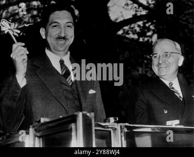 Präsident Aleman Waves Schlüssel zur Hauptstadt Präsident Miguel Aleman von Mexiko (links) winkt den Schlüssel zur Hauptstadt, den er ihm bei seinem Empfang gegeben hat, als er heute für mehrere Tage hier angekommen ist. Präsident Truman, sein Gastgeber, sieht nach rechts lächelnd aus. April 1947. (Foto von AP Wirephoto) Stockfoto