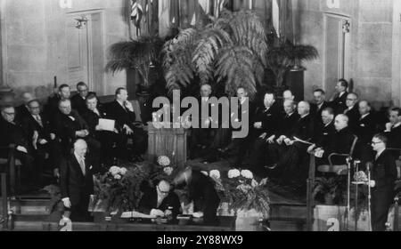 Spaak beginnt mit der Unterzeichnung eines historischen Vertrags -- Paul-Henri Spaak, Belgiens Premierminister und Außenminister, testet heute einen Stift, bevor er die erste Unterzeichnung des nordatlantikvertrags platziert, der jeder russischen Aggression mit einer gemeinsamen Verteidigung begegnen soll. Baron Silvercruys, belgischer Botschafter, steht links und John W. Foley Jr. vom US-Außenministerium beugt sich rechts von Spaak vor. Ein Dolmetscher steht ganz rechts. In der ersten Reihe befinden sich von links: Ernest Bevin, Halvard lange, Joseph Bech, Bjarni Benediktsson, Gustav Rasmussen, Präsident Truman, Dean Acheson, Lester Pearson, Robert Stockfoto