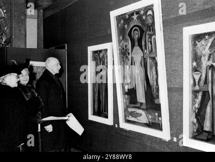 Athlone's View Australian Art in London -- der Earl und die Countess of Athlone und Mrs. Thomas Dunbabin (links vorne), die Frau des Direktors für Nachrichten und Informationen im Australia House, die sie begrüßten und die Anbetung der Könige bewunderten, ein Triptychon für die Kirche von M. D. Parton, das in der Sammlung von Mr. Peter Bellew steht. Der Earl of Athlone und Prinzessin Alice Countess of Athlone waren Besucher der Ausstellung für zeitgenössische australische Kunst, die jetzt in der Ausstellungshalle des Australia House in London stattfindet. (Dies wurde vom Australian News and Information Bureau arrangiert). Die Anzeige war Pre Stockfoto