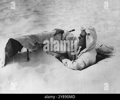 Schwer zu sehen, wie die Finnen, die weiße Mäntel trugen, um mit schneebedeckten Hintergründen zu verschmelzen, trägt dieser britische Wüstenkämpfer Overalls, die mit dem Sand verschmelzen. Seine Bren-Kanone ist ähnlich verdeckt, um ein Flecken aus der Luft zu verhindern. September 1941. (Foto von ACME). Stockfoto