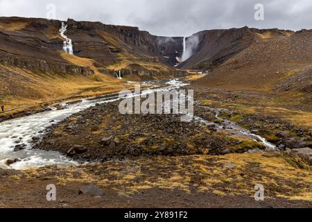 Hengifoss-Wasserfalllandschaft in Island mit Hengifossa-Flussschlucht und roten basaltischen Tonschichten. Stockfoto