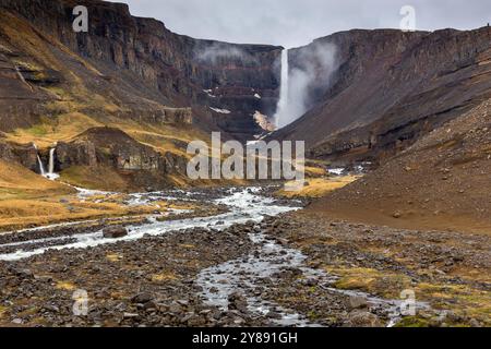 Hengifoss-Wasserfalllandschaft in Island mit Hengifossa-Flussschlucht und roten basaltischen Tonschichten. Stockfoto