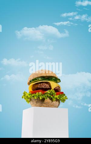 Ein köstlicher, frisch zubereiteter, hausgemachter Cheeseburger wird auf einem minimalistischen weißen Podium vor einem sanften blauen Hintergrund präsentiert. Stockfoto