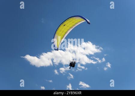 Person Paragliding unter blauem Himmel mit verstreuten weißen Wolken an einem sonnigen Tag, Paragliding, Bremm, Cochem, Cochem-Zell, Rheinland-Pfalz, Deutschland Stockfoto