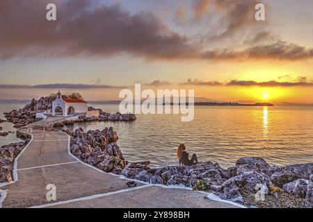 Eine Frau beim Sonnenaufgang der kleinen Kirche Agios Isidoros auf der Insel Chios, Griechenland, Europa Stockfoto