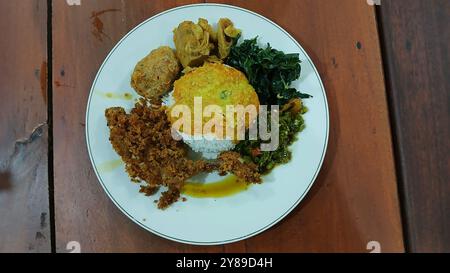 Nasi Padang mit gebratenem Huhn, Maniokblättern, gebratenen Kartoffeln, Chili-Sauce. Nasi Padang ist eines der beliebtesten Menüs in Indonesien Stockfoto