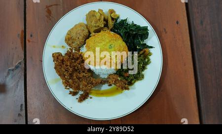 Nasi Padang mit gebratenem Huhn, Maniokblättern, gebratenen Kartoffeln, Chili-Sauce. Nasi Padang ist eines der beliebtesten Menüs in Indonesien Stockfoto