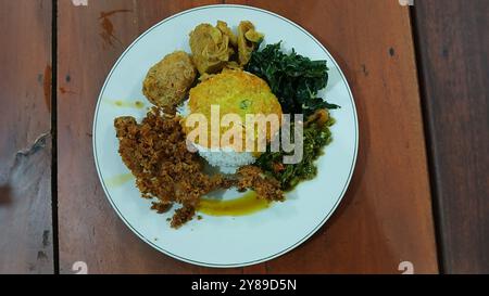 Nasi Padang mit gebratenem Huhn, Maniokblättern, gebratenen Kartoffeln, Chili-Sauce. Nasi Padang ist eines der beliebtesten Menüs in Indonesien Stockfoto