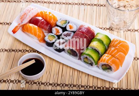 Sushi-Brötchen und Nigiri mit Lachs, Thunfisch, Avocado und Garnelen Stockfoto