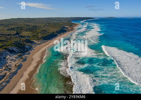 Sanddünen säumen einen Strand mit Brandung über einem felsigen Riff Stockfoto