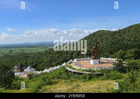 Große Skulptur von Lord Hanuman, der hinduistischen Gottheit, mit Blick auf den buddhistischen Tempel in Khao Wong Phrachan und die umliegende Landschaft, Lopburi, Thailand Stockfoto