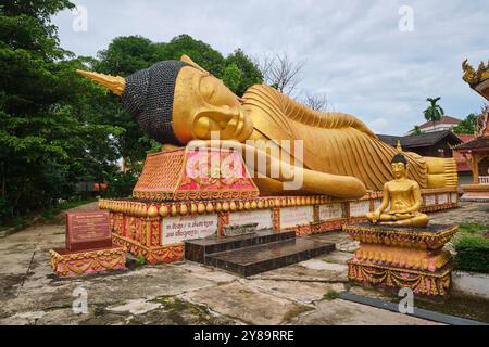 Ein großes, außen lackiertes, goldfarbenes, liegendes, entspannende, schlafende Buddha-Statue, Skulptur, Figur an einem bewölkten Tag. Bei Wat That Khao in Vientiane, Laos Stockfoto