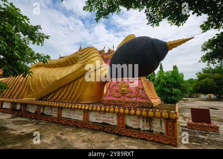 Ein großes, außen lackiertes, goldfarbenes, liegendes, entspannende, schlafende Buddha-Statue, Skulptur, Figur an einem bewölkten Tag. Bei Wat That Khao in Vientiane, Laos Stockfoto