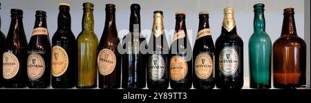 Reihe alter, antiker, Vintage- und Sammlerflaschen von Guinness in verschiedenen Farben und mit verschiedenen Etiketten. Stockfoto