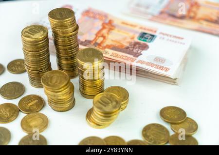 Banknoten Russlands in 5000 Rubel mit 10 Rubel Münzen auf dem Tisch. Blick von oben. Stockfoto