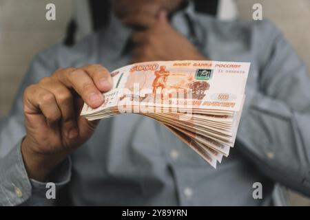 Mann, der Geld gibt, russische Rubel-Banknoten, im Amt - Bestechung und Korruption concept.russian-Rubel-Banknoten. Finanzthema. Stapel von Banknoten in Stockfoto