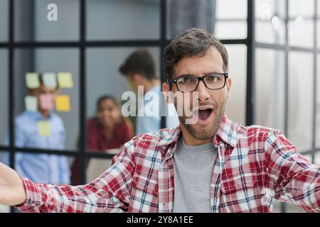Ein gutaussehender Geschäftsmann in einem karierten Hemd spreizte seine Arme weit Stockfoto