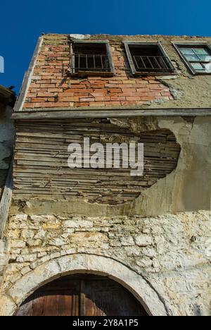 Ein historisches Haus mit Fachwerkjettings, das über einer Gasse im Gorica-Viertel von Berat in Albanien hinausragt. Berat ist ein UNESCO-Weltkulturerbe Stockfoto
