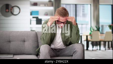 Sorgte Mitte der erwachsene Mann leidet unter Kopfschmerzen zu Hause Stockfoto