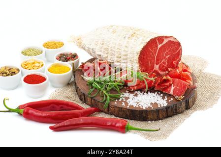 In Scheiben geschnitten geheilt Coppa mit Gewürzen und einem Zweig Rosmarin. Auf weiß isoliert. Stockfoto