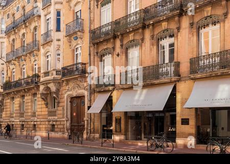 Typische Straßensicht auf die französischen Balkone in der Innenstadt von Toulouse mit evert Apartment, wo man draußen sitzen und das Stadtleben draußen genießen kann Stockfoto