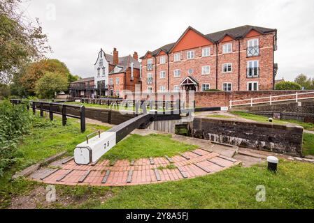 Herrliche Kanalszene mit Schleusentoren und Fußgriffen, 'Big Lock' Pub und Kanalgehäuse. Auf dem Trent & Mersey in Middlewich, Cheshire, Großbritannien. Stockfoto