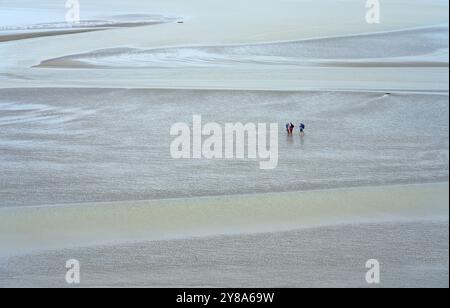 Gruppe von Menschen, die bei Ebbe im wattenmeer vor Le Mont saint Michel wandern Stockfoto