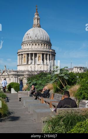 Die Leute genießen den Dachgarten in der 25 Cannon Street, London, mit Blick auf die berühmte St. Pauls Cathedral. Stockfoto