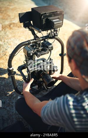 Fotograf, Hände und Videokamera im Freien für Filmproduktion, Videographie und Naturdokumentation. Kameramann, nimmt Ausrüstung auf und bereitet sie vor Stockfoto