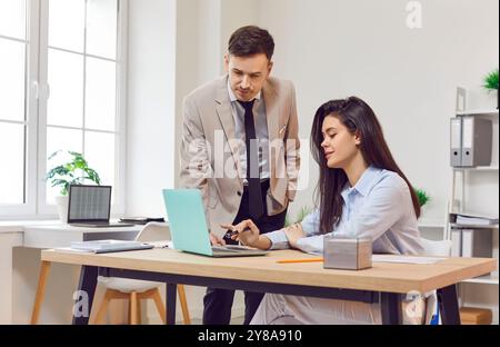 Zwei junge Firmenmitarbeiter arbeiten im Büro und diskutieren über neue Jobprojekte. Stockfoto