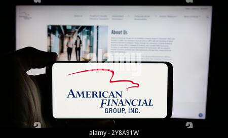Person, die ein Mobiltelefon mit dem Logo des US-amerikanischen Unternehmens American Financial Group Inc. Auf dem Bildschirm vor der Unternehmenswebseite hält. Schwerpunkt auf dem Display des Telefons. Stockfoto