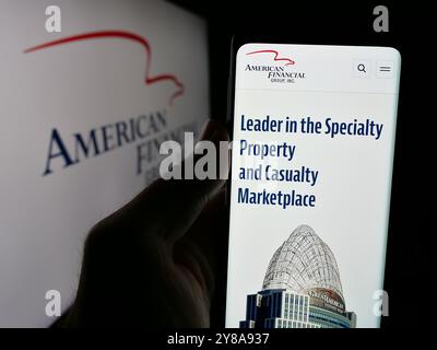 Person, die ein Mobiltelefon hält, mit der Webseite der US-amerikanischen Financial Group Inc. Vor dem Logo auf dem Bildschirm angezeigt wird. Konzentrieren Sie sich auf die Mitte des Telefondisplays. Stockfoto