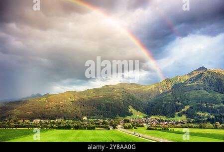 Regenbogen über grünen Berggipfeln mit Wolken in den österreichischen Alpen im Sommer in Kaprun, hohe Tauern - Maiskogel Stockfoto