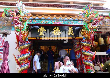 Außenansicht des Wat Hua Lamphong, einem königlich buddhistischen Tempel der dritten Klasse, im Bang Rak District von Bangkok, Thailand, Asien. Drachenstatuen schmücken und bewachen den Eingang. Man sieht, wie Menschen ihren Respekt und ihre Einhaltung erweisen. Stockfoto