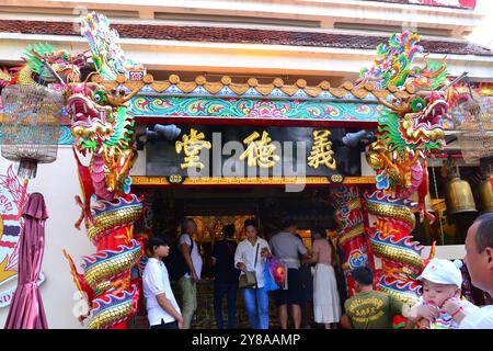 Außenansicht des Wat Hua Lamphong, einem königlich buddhistischen Tempel der dritten Klasse, im Bang Rak District von Bangkok, Thailand, Asien. Drachenstatuen schmücken und bewachen den Eingang. Man sieht, wie Menschen ihren Respekt und ihre Einhaltung erweisen. Stockfoto