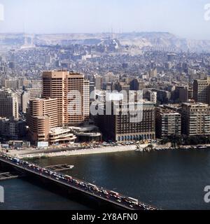 Blick vom Kairo Turm auf der Nilinsel Gezira auf das Ostufer des Nil mit dem Shepheards Hotel Bildmitte und das noch im Bau befindliche Semiramis Intercontinental Hotel, im Hintergund das Gebirge al-Mukattam, Ägypten um 1987. 90010000224 Stockfoto