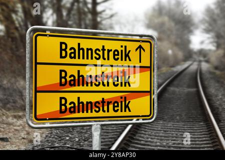 'FOTOMONTAGE, Schild mit der Aufschrift ''Eisenbahnstreik'' vor leeren Bahngleisen', FOTOMONTAGE, Schild mit Aufschrift Bahnstreik vor leer Stockfoto