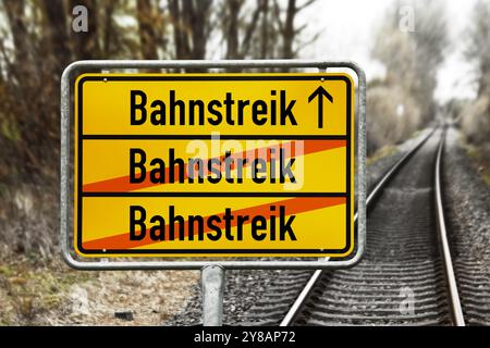 'FOTOMONTAGE, Schild mit der Aufschrift ''Eisenbahnstreik'' vor leeren Bahngleisen', FOTOMONTAGE, Schild mit Aufschrift Bahnstreik vor leer Stockfoto