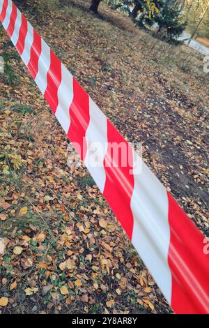 Rote und weiße Linien des Zaunbandes. Das rote und weiße Band, das die Bewegung verbietet, umzäunt. Warnband. Stockfoto