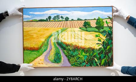 London, Großbritannien. 4. Oktober 2024. Techniker präsentieren „Path through Wheat Field, July“ von David Hockney (Est. £2.000.000 - 3.000.000) bei einer Vorschau auf die Höhepunkte der Frieze Week Modern and Contemporary Art Auctions von Phillips. Die Lose werden am 10. Und 11. Oktober in den Galerien des Berkeley Square von Phillips versteigert. Quelle: Stephen Chung / Alamy Live News Stockfoto