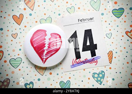 FOTOMONTAGE, Kalenderseite vom 14. Februar und gebrochenes Herz, symbolisches Foto-Argument zum Valentinstag, FOTOMONTAGE, Kalenderblatt vom 14. Februar. Febru Stockfoto