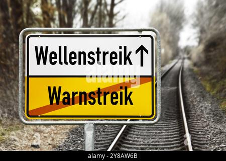 FOTOMONTAGE, Schild mit der Aufschrift Wave Strike und durchgestrichene Aufschrift Warning Strike vor leeren Bahngleisen, FOTOMONTAGE, Schild Stockfoto