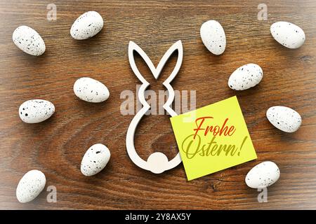 FOTOMONTAGE, Osterhasenfigur und Notiz mit der Aufschrift Frohe Ostern, FOTOMONTAGE, Osterhasenfigur und Zettel mit Aufschrift Frohe Ostern Stockfoto